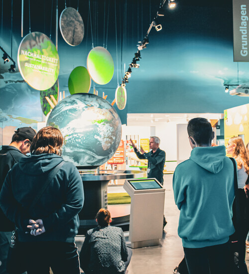 Gruppe bei Führung am interaktiven Globus in der KLIMA ARENA.