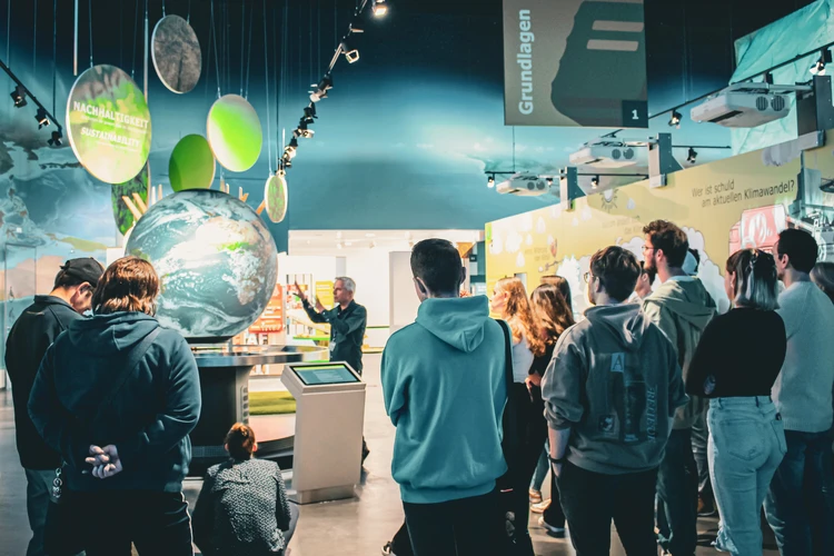 Gruppe bei Führung am interaktiven Globus in der KLIMA ARENA.