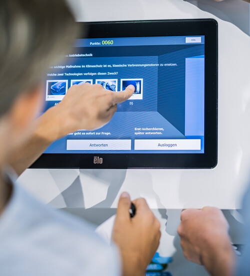 Schüler bei der Bedinung eines KLIMA-Quiz Terminals in der Ausstellung.