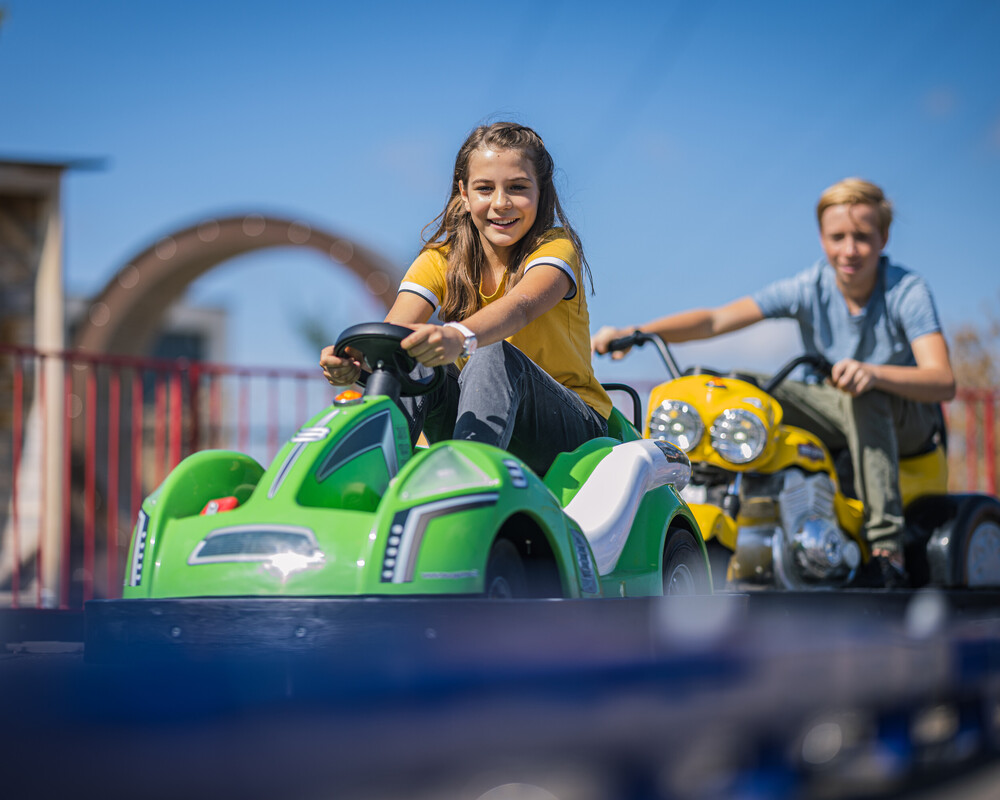 Kinder auf E-Kartbahn im Außenbereich der KLIMA ARENA.
