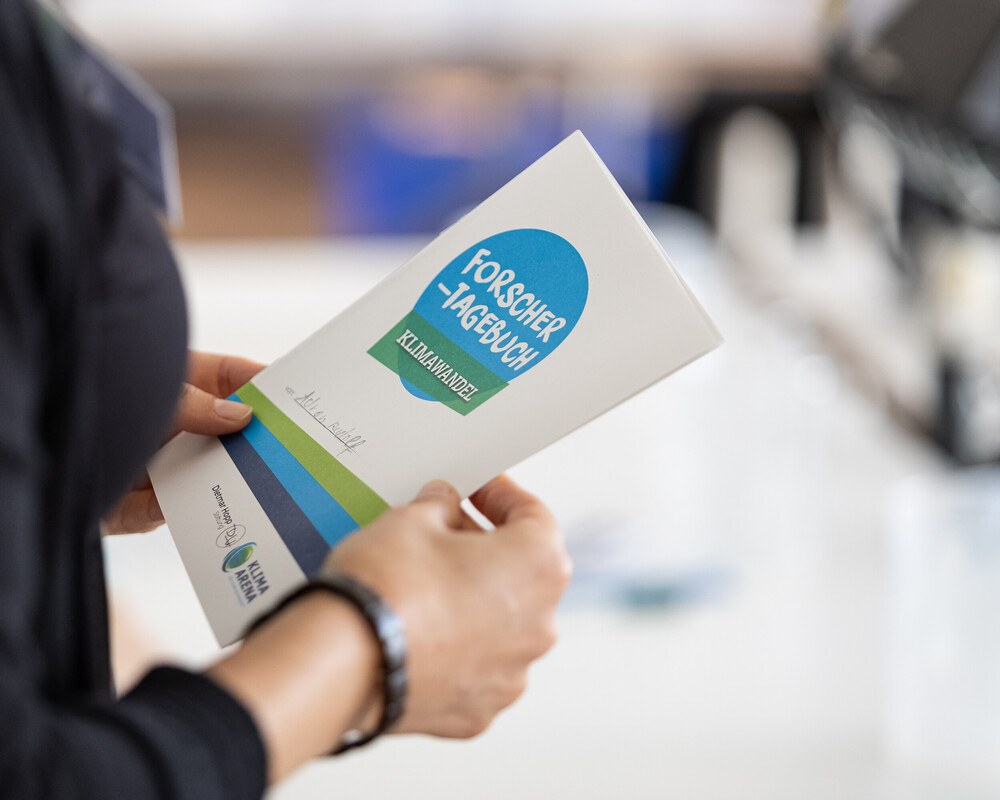 Nahaufnahem des Forschertagebuchs, in dem Schüler die Ergebnisse ihrer Experimente festhalten.